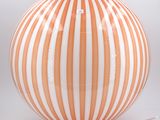 a large orange and white striped lamp on a table