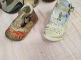 several pairs of children ' s shoes are lined up on a table
