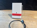 a white box with a red stripe on it sitting on a wooden table