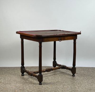 une petite table avec un plateau et des pieds en bois, posée sur un sol recouvert de moquette