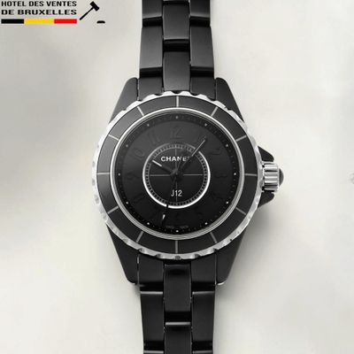 a close up of a black watch on a white surface