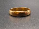 une bague en or posée sur une surface noire