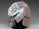 un chapeau blanc orné d'un ruban rose posé sur la tête d'un mannequin