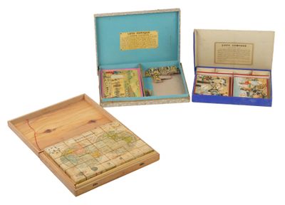 trois boîtes en bois contenant des cartes géographiques et des cartes à jouer, posées sur une surface blanche