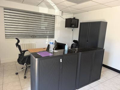 un bureau équipé d'un bureau, d'armoires et d'une télévision