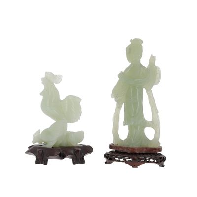 pair of jade figurines of a man and a woman on a stand