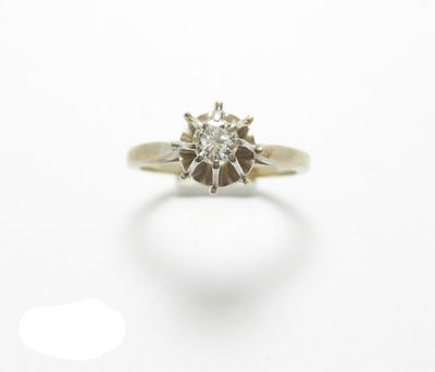 gros plan d'une bague en diamant sur une surface blanche
