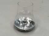 un verre transparent avec un pied en métal posé sur une table