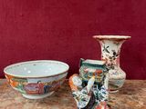 trois vases posés sur une table à côté d'un bol