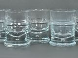 six verres à shot alignés en rang sur une table