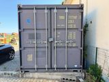a large gray container sitting on the side of the road