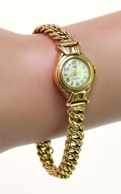 une montre-bracelet en or au poignet d'une femme
