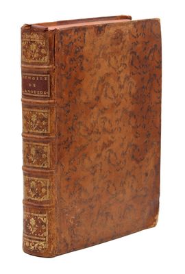 un vieux livre à la couverture brune posé sur une surface blanche