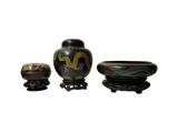 trois vases et un petit bol posés sur un support