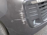 a car that has been dented and is parked on the side of the road
