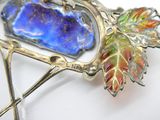 une photo d'une broche ornée d'une feuille