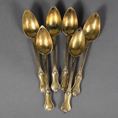 six spoons are arranged in a row on a gray surface