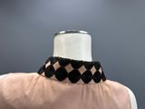 a close up of a mannequin with a black and white checkered collar