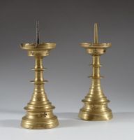Paire de pique-cierges en bronze, fût à deux nœuds aplatis, …