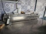 stainless steel counter top in a commercial kitchen with a microwave and toaster on it