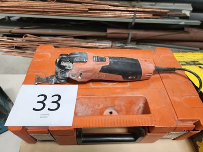 une perceuse filaire posée sur une boîte sur laquelle est apposée une étiquette de prix