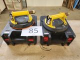deux crics hydrauliques portatifs jaunes et noirs posés sur une table en bois