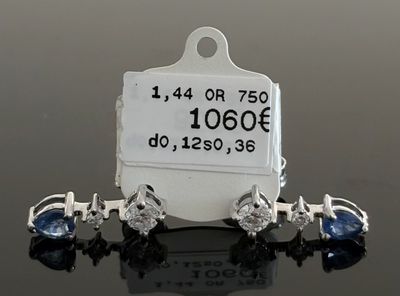 paire de boucles d'oreilles en saphir et diamants avec étiquette de prix sur fond noir