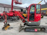 une voiture rouge garée sur un parking