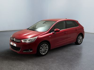La voiture rouge est garée dans une pièce aux murs blancs.