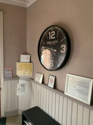 une horloge accrochée au mur au-dessus d'un banc dans une pièce