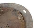 a dirty metal pan with a handle on a white surface