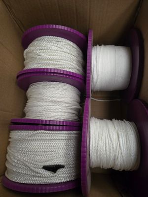 deux bobines de corde blanche dans une boîte munie de poignées violettes