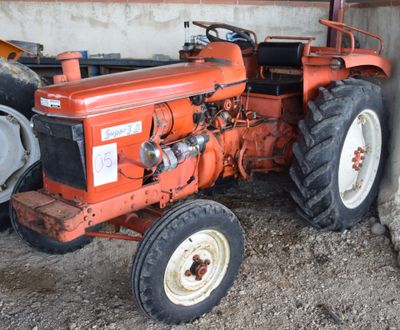 a red tractor that is parked in a barn