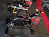 several stationary exercise bikes are lined up in a row in a gym
