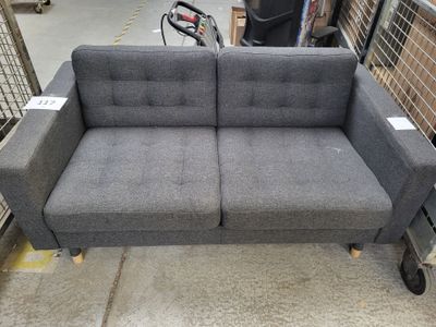 a couch that is sitting on a cart in a warehouse