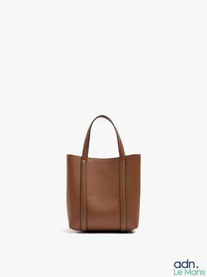 the small leather tote bag is brown and has a zipper closure