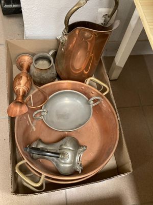 une boîte contenant tout un tas de casseroles et de poêles en cuivre