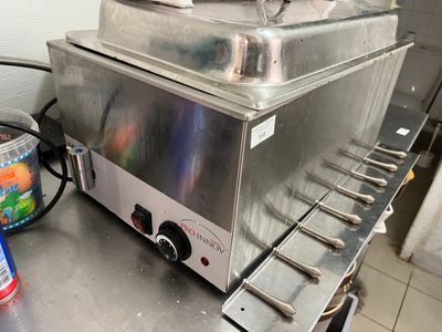 un réchauffeur de plats en argent posé sur un comptoir en métal