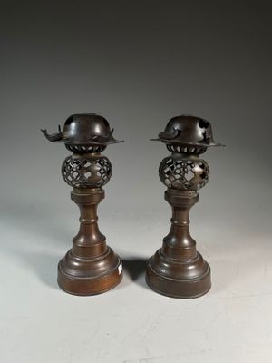 une paire de bougeoirs anciens en bronze surmontés de chapeaux