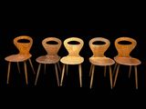 quatre chaises en bois sont alignées sur fond noir