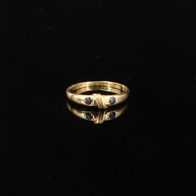 gros plan d'une bague en or sur une surface noire
