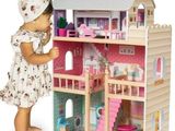 La maison de poupées est en bois et a un toit rose.