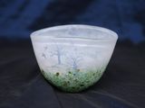 un bol blanc orné d'un motif vert et bleu