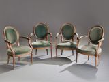 four chairs with green upholstered cushions are arranged in a circle