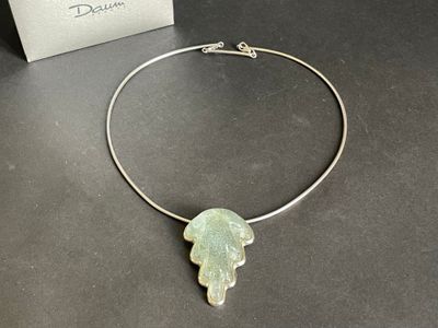 silver plated necklace with a green leaf pendant on it