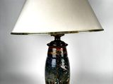 a lamp that is sitting on a table with a lamp shade on it