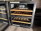 two wine coolers that are open on the floor