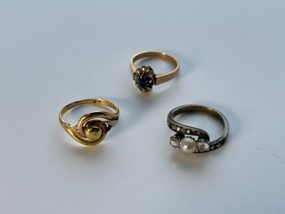 Trois bagues différentes sont présentées sur une table avec un fond blanc.