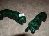 deux figurines vertes représentant des lions, posées par terre