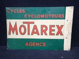 une ancienne enseigne Motorex est représentée sur un fond noir